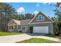 Charming home with a two-car garage and inviting front porch, showcasing lovely curb appeal at 121 Pebble Creek Dr, Stony Point, NC 28678
