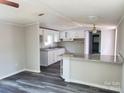 Bright open kitchen features white cabinets, granite countertops, and gray wood-look floors at 230 Ellen St, Salisbury, NC 28146