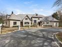 Expansive stone home with a circular driveway, a gated entrance, and meticulously maintained landscaping at 8525 Double Eagle Gate Way # 2, Charlotte, NC 28210