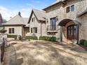 Charming stone home with a covered front entrance, well-manicured bushes, and a cozy bench at 8525 Double Eagle Gate Way # 2, Charlotte, NC 28210