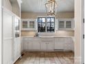 Bright kitchen features white cabinets, farmhouse sink under a large window, and unique tile flooring at 8525 Double Eagle Gate Way # 2, Charlotte, NC 28210