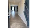 Inviting entryway with wood-look flooring leading to the living area and staircase with wooden railing at 110 Silver Oak Cir, Rockwell, NC 28138