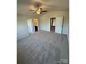 Main bedroom with carpeted floors, ceiling fan, and access to bathroom at 1303 Dodd St, Shelby, NC 28152