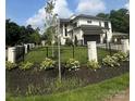 Beautiful exterior view of a two-story home with black trim, manicured lawn, black metal fence and flower bed at 4142 Pineview Rd, Charlotte, NC 28211
