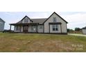 Charming two-story residence showcasing a covered porch, light-colored siding, and contrasting dark trim, providing a warm curb appeal at 1405 Coppergate Dr, Salisbury, NC 28147
