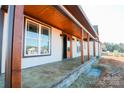 Covered front porch with stained wood posts and a stained concrete floor at 1405 Coppergate Dr, Salisbury, NC 28147