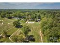 Aerial view of houses along a golf course with beautiful green fairways and mature trees at 218 Fairway Dr, Shelby, NC 28150