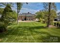 Expansive backyard featuring a lush lawn, mature trees, and brick home with lots of windows at 218 Fairway Dr, Shelby, NC 28150