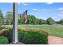 A gorgeous golf course view from a porch with American flag in the background at 218 Fairway Dr, Shelby, NC 28150