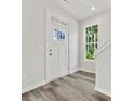 Bright entryway with white door, wood-look floors, and staircase at 2121 Acclaim St, Charlotte, NC 28205