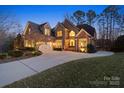 Charming brick home with a spacious driveway, lush landscaping, and inviting exterior lighting at 2012 Tomshire Dr, Gastonia, NC 28056