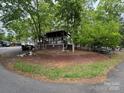 Exterior view of the home surrounded by lush trees, showing the driveway and the charming setting at 102 Catawba Ct # F190, Mount Gilead, NC 27306