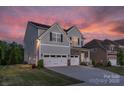 Two-story house with gray siding, stone accents, and a three-car garage at 4212 Linville Way, Fort Mill, SC 29707