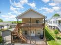 Two-story home featuring a spacious back deck with stairs leading down to a fenced-in backyard at 159 Badin Lake Cir, New London, NC 28127