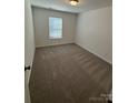 Simple bedroom with neutral carpeting and a window with blinds at 5033 Falstone Dr, Charlotte, NC 28269