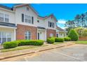 Two story brick and white townhome with landscaping and parking at 6436 Mallard View Ln, Charlotte, NC 28269