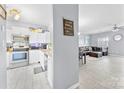 Open concept kitchen with stainless steel appliances, white cabinets, and view into living room at 6436 Mallard View Ln, Charlotte, NC 28269