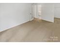 Spacious carpeted bedroom featuring a glass paneled door to the bathroom and ample closet space at 6003 Treetop Ct, Charlotte, NC 28212