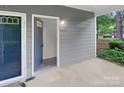Inviting entryway featuring a light gray door, modern house number display, and durable concrete flooring at 6003 Treetop Ct, Charlotte, NC 28212