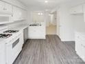 Bright kitchen with white cabinetry, modern appliances, sleek countertops, and stylish gray flooring at 6003 Treetop Ct, Charlotte, NC 28212