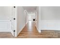 Bright hallway with hardwood floors and decorative wainscoting, leading to a cozy living area at 2003 Cedar Falls Dr # 69, Waxhaw, NC 28173