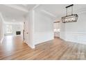 Spacious living room with hardwood floors, wainscoting, and a modern light fixture at 2003 Cedar Falls Dr # 69, Waxhaw, NC 28173
