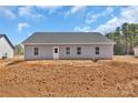 Backyard with newly installed vinyl siding, a gray roof, a white back door, and a partially graded yard at 6122 Lowder Rd, Salisbury, NC 28147