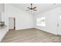 Well-lit open concept living room featuring wood floors, white walls, and seamless transition to the modern kitchen at 6122 Lowder Rd, Salisbury, NC 28147