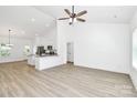 Bright, open-concept living room with hardwood floors, white walls, a ceiling fan, and seamless access to the kitchen at 6122 Lowder Rd, Salisbury, NC 28147