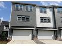 Townhome featuring a two-car garage and modern design with gray and white siding at 320 Ferebee Pl # Brx0021, Charlotte, NC 28213