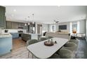 Open layout boasts a modern kitchen with island, a dining area, and a cozy living space filled with natural light at 11507 Valley Oaks Ln, Stanfield, NC 28163