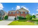 Inviting two-story brick home with green shutters and lush green lawn under a partly cloudy sky at 14447 Waterlyn Dr, Charlotte, NC 28278