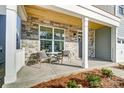 Welcoming front porch featuring stone accents, seating, and a stylish wood ceiling, perfect for relaxing outdoors at 130 Summerhill Dr # 16, Mooresville, NC 28115