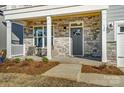 Inviting front porch with stone accents, comfortable seating, and stylish wood ceiling, creating a welcoming entrance at 130 Summerhill Dr # 16, Mooresville, NC 28115