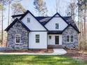 Two-story home with stone and white siding, a black roof and a front porch at 248 Pioneer Dr # 990, Mount Gilead, NC 27306