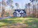 Two-story house nestled in a wooded lot, featuring stone and white siding at 248 Pioneer Dr # 990, Mount Gilead, NC 27306