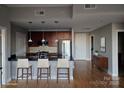 Virtually staged kitchen with island and seating at 701 Royal Ct # 309, Charlotte, NC 28202