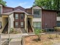 Two-story townhome featuring earth tone colors, and a stairway leading to the front door at 7378 Winery Ln, Charlotte, NC 28227