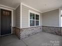 Inviting front porch featuring brick accents and ample space for outdoor seating at 4679 Hopsack Dr # Cal0108, Indian Trail, NC 28079
