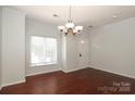 Bright dining room featuring hardwood floors, a chandelier, and a window at 1125 Kurt Ct, Charlotte, NC 28209