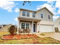 Inviting two-story home boasts a covered front porch and an attached two-car garage on a beautiful day at 3206 Thorpe Ln, Clover, SC 29710