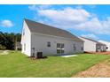 Expansive backyard featuring a lush lawn, a sliding glass door, and a view of neighboring homes at 126 Brixham Loop, Troutman, NC 28166