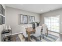 Dining area with wood table, seating for six, stylish rug, and sliding glass doors to the patio at 420 Serenity Cir, Cramerton, NC 28032