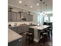 Modern kitchen with granite countertops, stainless steel appliances, and a stylish island with seating at 2044 Sweet William Dr, Harrisburg, NC 28075
