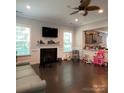 Cozy living room with a fireplace, dark wood floors, bright windows, and an open concept layout at 2044 Sweet William Dr, Harrisburg, NC 28075
