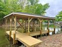 This newly constructed wooden dock offers a perfect spot for relaxation and lake access at 416 Plantation Way, Mount Gilead, NC 27306