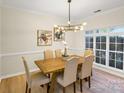 Bright dining room featuring a modern chandelier, light wood floors, and a large window at 2907 Meherrin Ct, Waxhaw, NC 28173