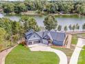 Stunning waterfront home with a three-car garage, lush lawn, and beautiful lake views at 116 Emmaline Ct, Troutman, NC 28166