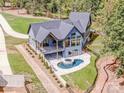Back exterior view of the house with a swimming pool, hot tub, and covered porch at 116 Emmaline Ct, Troutman, NC 28166
