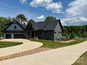 Lakefront two-story home with a winding driveway and expertly landscaped yard at 116 Emmaline Ct, Troutman, NC 28166
